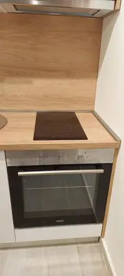 a stove in a kitchen with a wooden counter top at Biser Apartmani in Podgorica