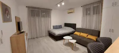 a living room with a couch and a bed at Biser Apartmani in Podgorica