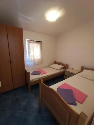 a small room with two beds and a window at TLM Apartments in Budva