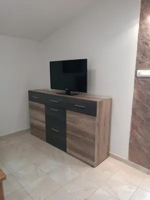 a tv sitting on top of a wooden dresser at TLM Apartments in Budva