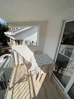 a balcony with a table and chairs on a balcony at Apartmani Resetar in Sutomore