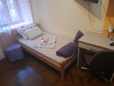 a small bed in a room with a desk at Centar Starog Grada in Kotor