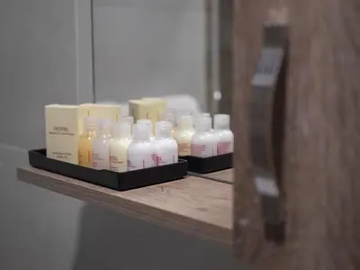 a shelf with a bunch of bottles of soap at Hotel Tara Becici in Budva