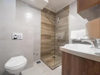 a bathroom with a shower and a toilet and a sink at Hotel Tara Becici in Budva