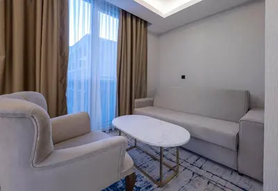 a living room with a couch and a table and chairs at Hotel Tara Becici in Budva