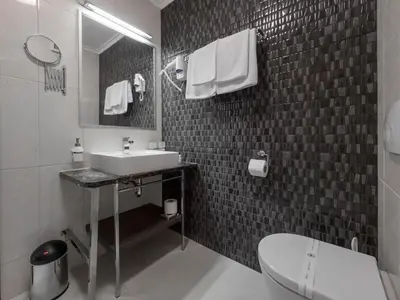 a bathroom with a sink and a toilet and a mirror at Hotel Tara Becici in Budva