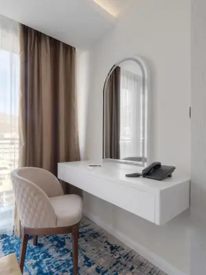 a dressing table with a mirror and a chair at Hotel Tara Becici in Budva