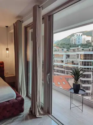 a bedroom with a large window with a view of a city at Golden Details Apartment in Rafailovici