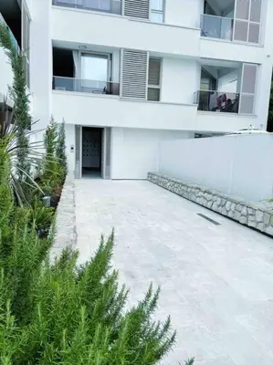 a large white building with a courtyard in front of it at Golden Details Apartment in Rafailovici