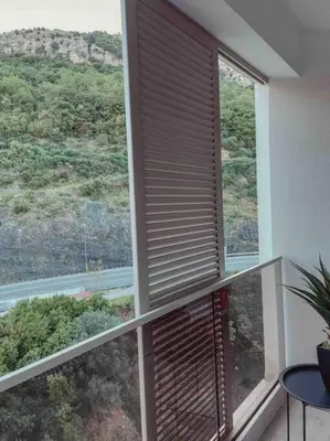 a large window with a view of a mountain at Golden Details Apartment in Rafailovici