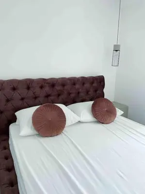 a white bed with two pillows on top of it at Golden Details Apartment in Rafailovici