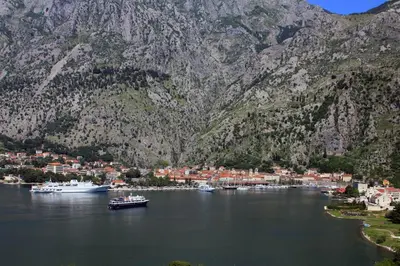 a group of boats in a body of water with mountains at Angelia Apartment in Kotor