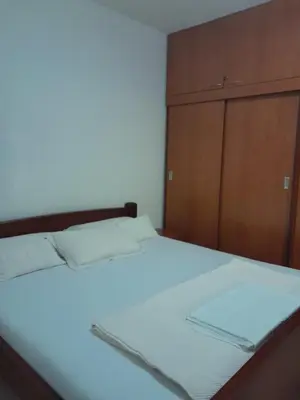 a bedroom with a bed and a wooden cabinet at Angelia Apartment in Kotor