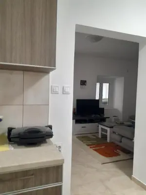 a kitchen and a living room with a couch at Angelia Apartment in Kotor