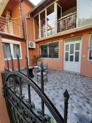 a house with a balcony and a porch with a fence at Angelia Apartment in Kotor