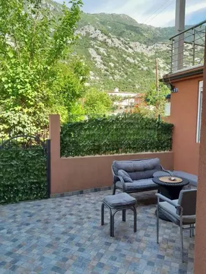 a patio with chairs and a table and a couch at Angelia Apartment in Kotor