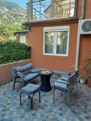 a patio with chairs and tables and a building at Angelia Apartment in Kotor