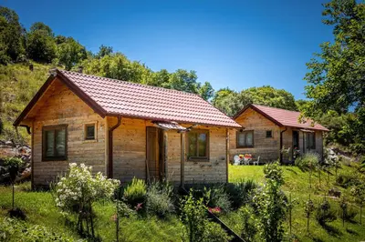 two small wooden houses in a field of grass at Boljesestre Lake retreat in Golubovci