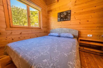 a bedroom with a bed in a log cabin at Boljesestre Lake retreat in Golubovci