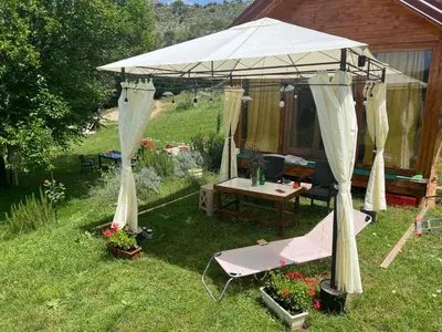 a tent with a table and a bench in a yard at Boljesestre Lake retreat in Golubovci