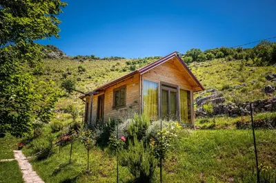 a small wooden house in a field of grass at Boljesestre Lake retreat in Golubovci