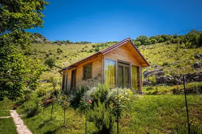 a small wooden house in a field of grass at Boljesestre Lake retreat in Golubovci