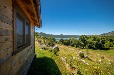 a window on the side of a house with a view at Boljesestre Lake retreat in Golubovci