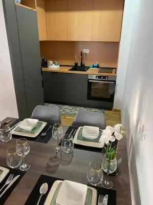 a kitchen with a table with plates and wine glasses at Apartment Olivia in Becici