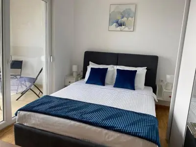 a bedroom with a large bed with blue pillows at Apartment Olivia in Becici