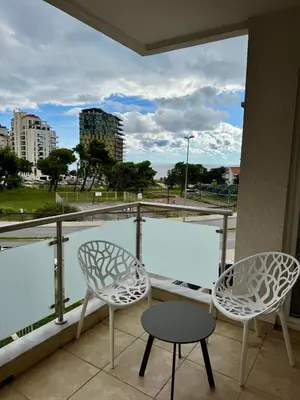 two chairs and a table on a balcony with a view at Seaside Apartment in Becici in Budva