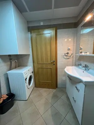 a bathroom with a washing machine and a sink at Seaside Apartment in Becici in Budva