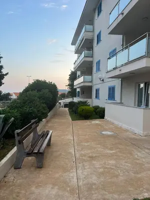 a bench sitting on a sidewalk next to a building at Seaside Apartment in Becici in Budva