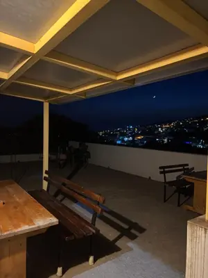 a patio with benches and a view of a city at night at Old house7 in Bar