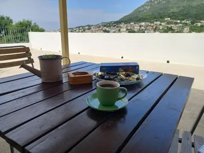 a table with a plate of food and a cup of coffee at Old house7 in Bar