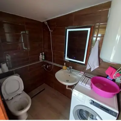 a bathroom with a toilet and a sink and a washing machine at Old house7 in Bar