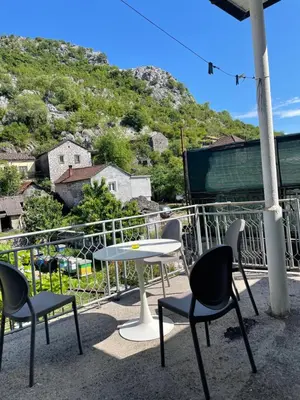 a table and chairs on a balcony with a mountain at Honey Home in Podgorica