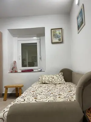 a small bedroom with a bed and a window at Honey Home in Podgorica