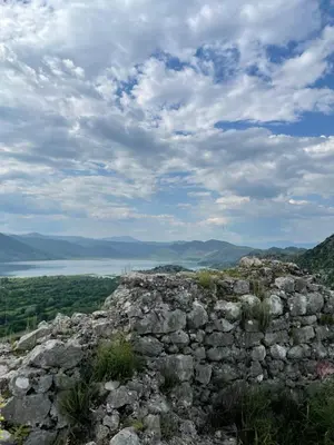 a stone wall on top of a hill with a lake at Honey Home in Podgorica