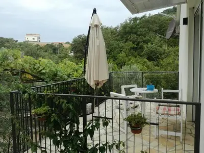 a balcony with an umbrella and a table and chairs at Apartmani Stanislav in Petrovac na Moru