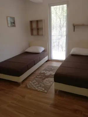 two beds sitting in a room with a window at Apartmani Stanislav in Petrovac na Moru