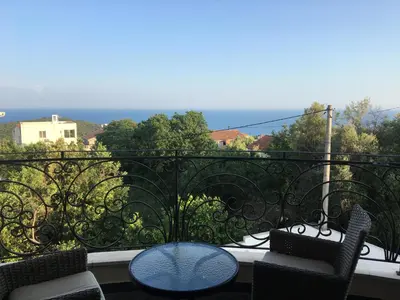 a balcony with a table and chairs and the ocean at Apartment Jasmina in Krimovice