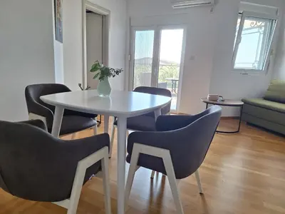 a white table with chairs and a vase of flowers on it at Apartment Jasmina in Krimovice
