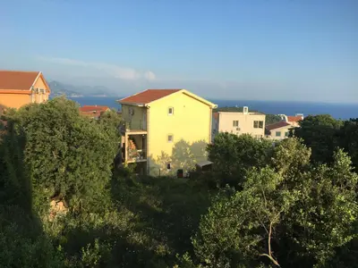 a group of houses on a hill with the ocean in the background at Apartment Jasmina in Krimovice