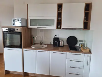 a small kitchen with white cabinets and a sink at Apartment Jasmina in Krimovice