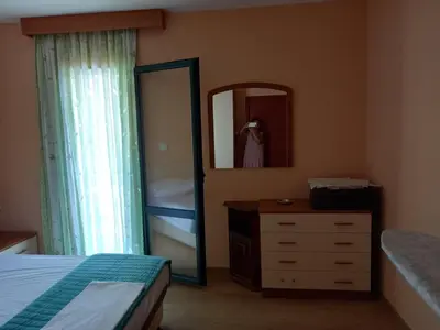 a bedroom with a bed and a dresser and a mirror at Apartman Maja in Sveti Stefan