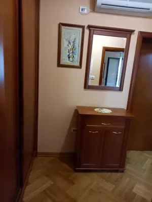 a bathroom with a wooden vanity and a mirror at Apartman Maja in Sveti Stefan