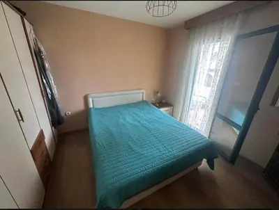 a small bedroom with a bed with a blue blanket at Apartman Maja in Sveti Stefan