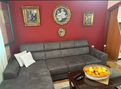 a living room with a couch and a table with a bowl of oranges at Apartman Maja in Sveti Stefan