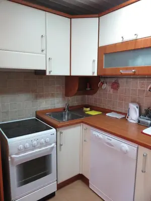 a kitchen with white cabinets and a sink at Apartman Maja in Sveti Stefan