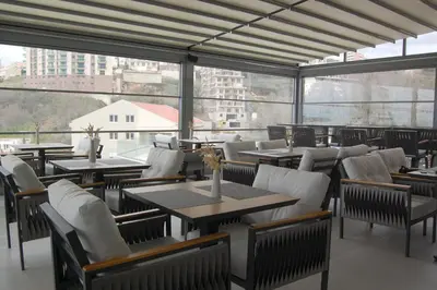 a restaurant with tables and chairs and large windows at Status-M Apartments 112 in Becici